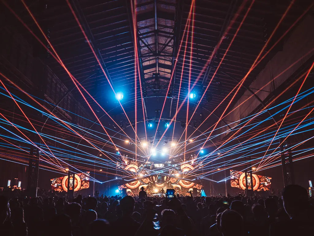 Orange and blue laser beams projecting overhead a crowd