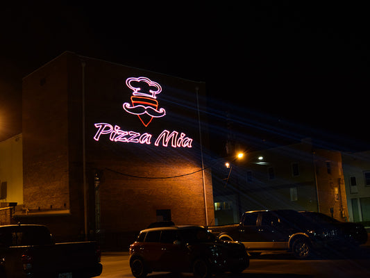 Lasers display a logo on a side of a building.